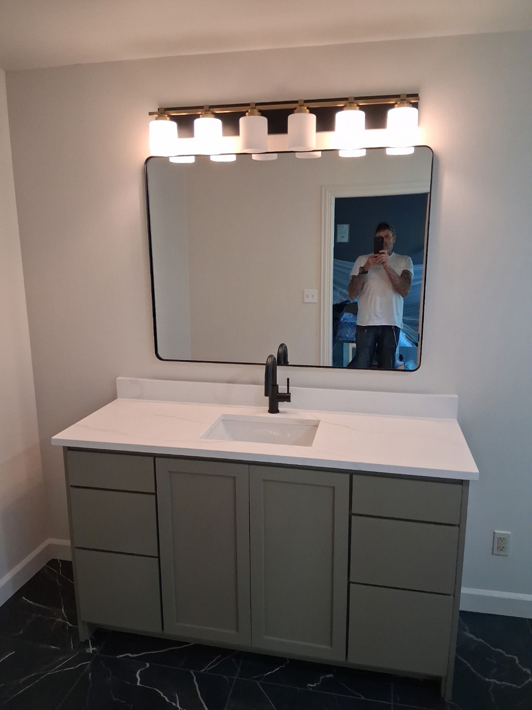 Custom vanity with quartz countertop, 5-light vanity bar, and black marble floor tile